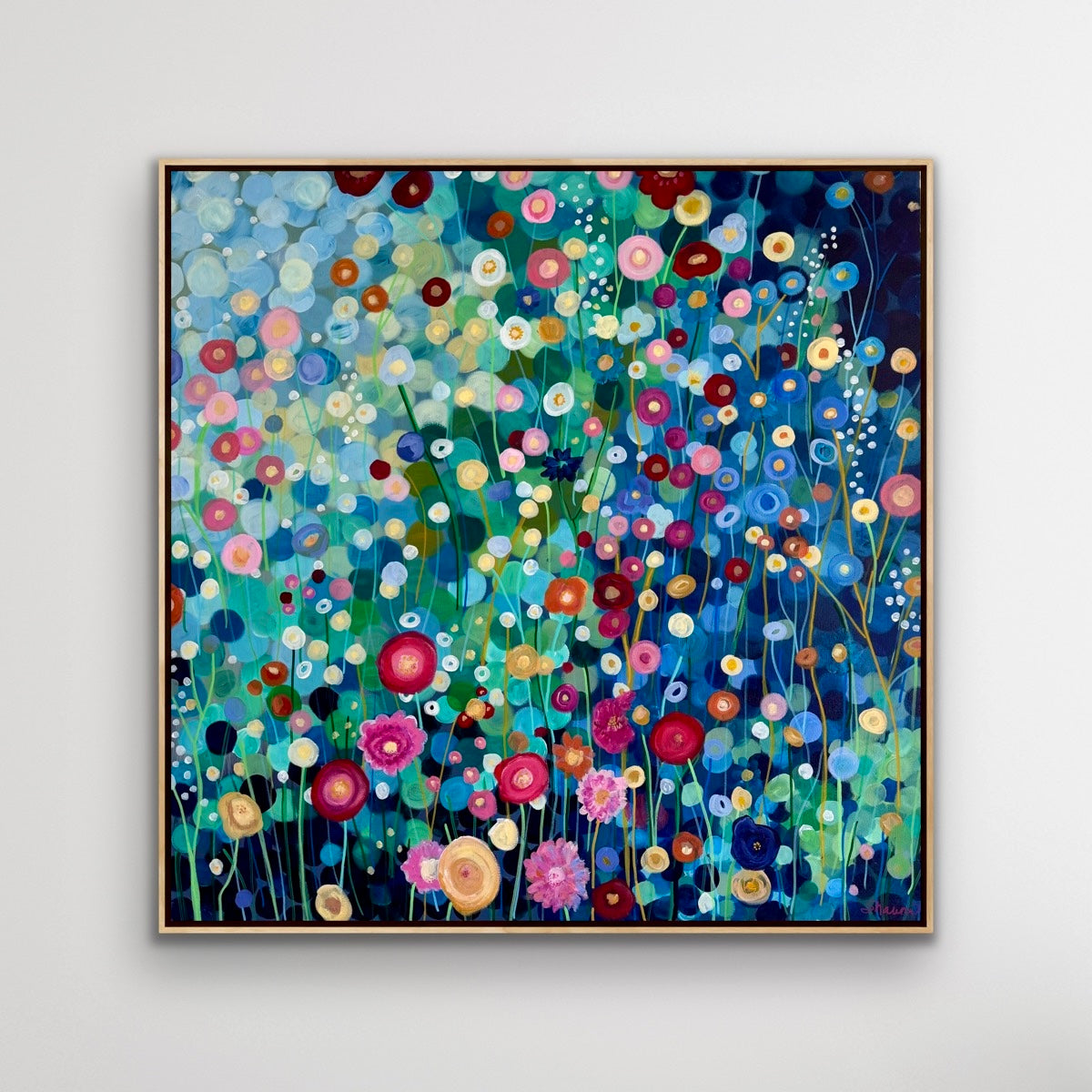 Framed painting of colorful flowers on a white wall
